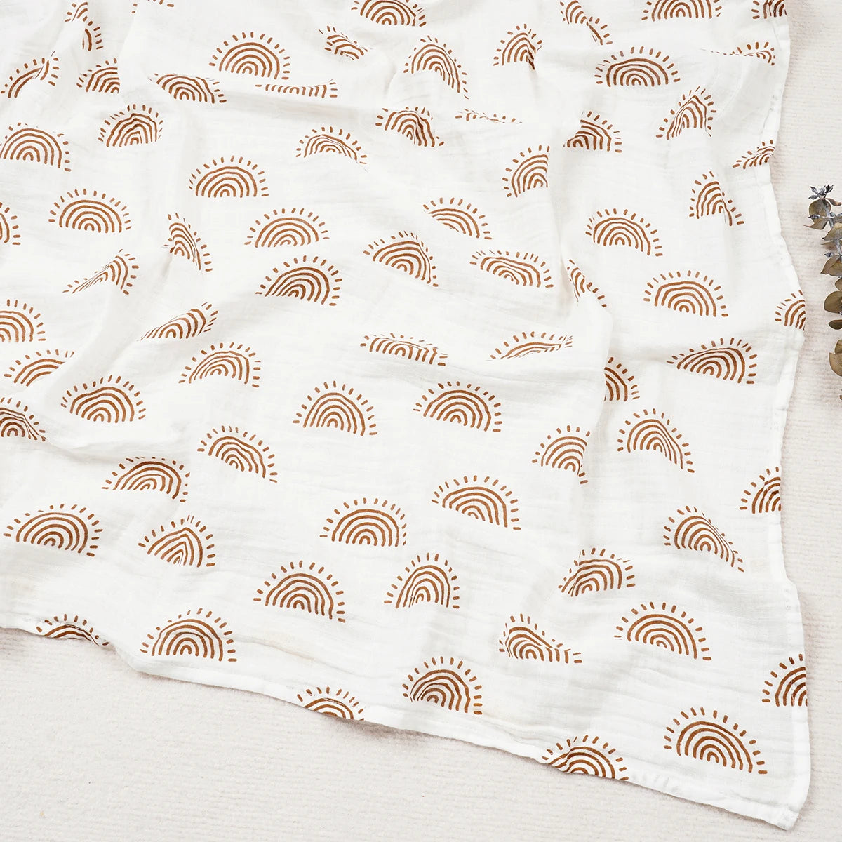 White fabric with brown rainbow pattern on a light wooden surface
