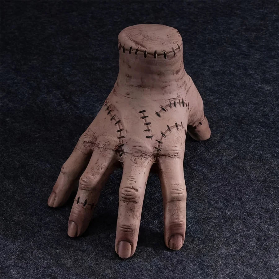 Clay model of a hand with stitched details on a dark background