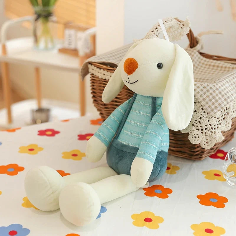 Plush toy rabbit with a blue sweater on a floral-patterned surface