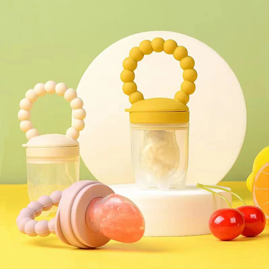 Set of baby teething toys on a yellow surface with a green background