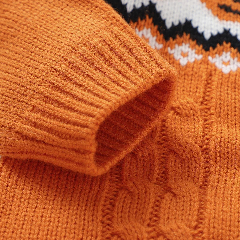 Close-up of an orange knitted sweater with a patterned design.
