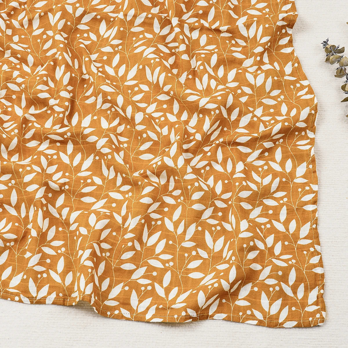 Fabric with white leaf pattern on a mustard yellow background