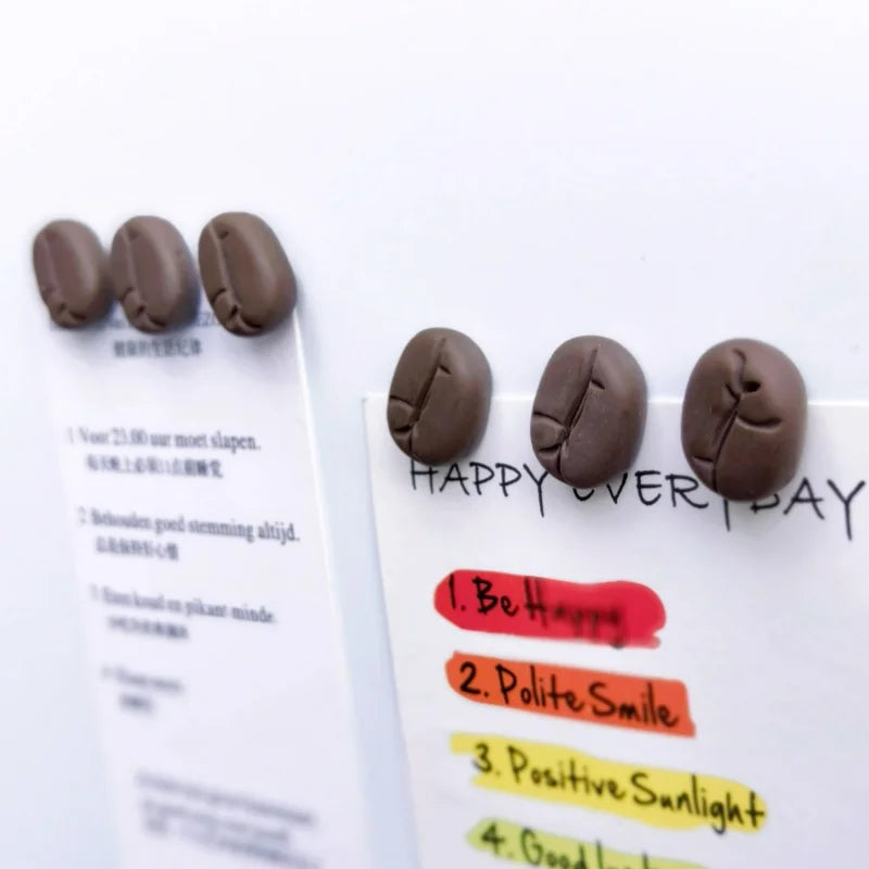 Coffee bean magnets on a piece of paper with motivational text.