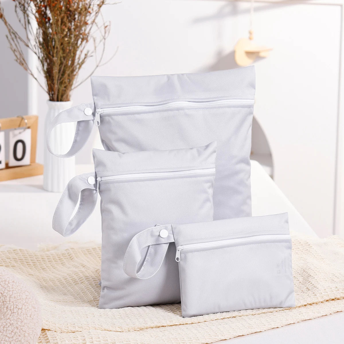 Set of gray pouches on a light surface with a blurred indoor background