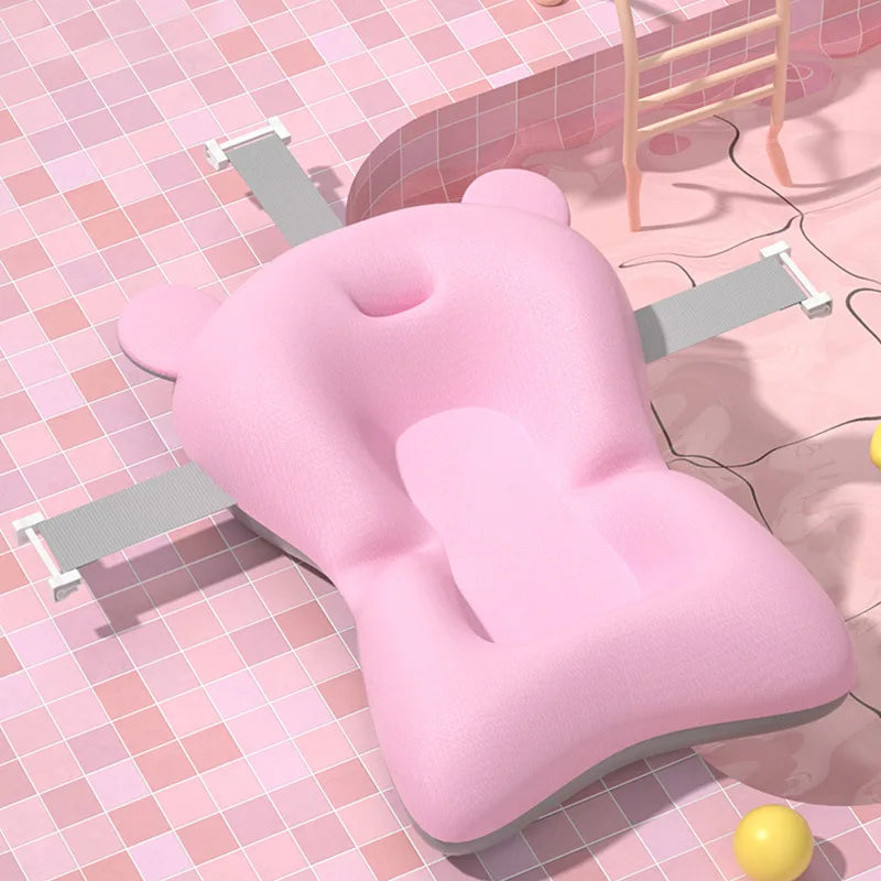 Pink bathtub pillow on a tiled bathroom floor with a yellow ball and bathtub.