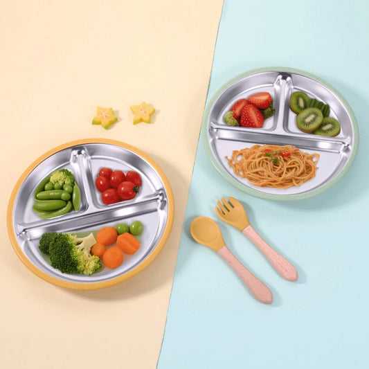 Two children's divided plates with food and utensils on a light blue and beige background.