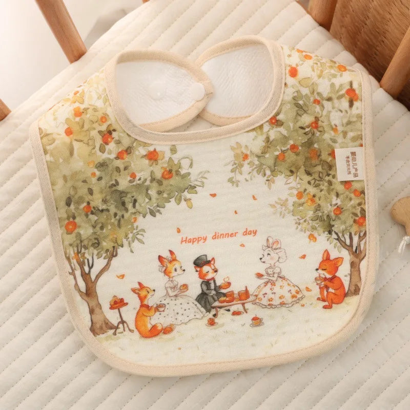 Baby bib with cartoon foxes and a rabbit sitting under an apple tree, on a textured surface.