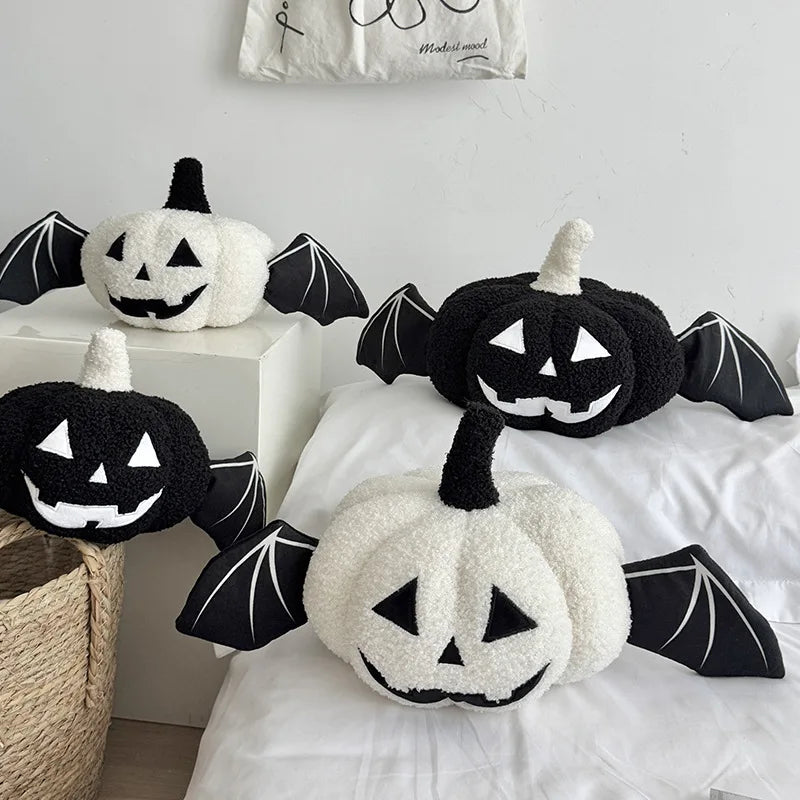 Halloween-themed plush toys resembling pumpkins and bats on a bed.