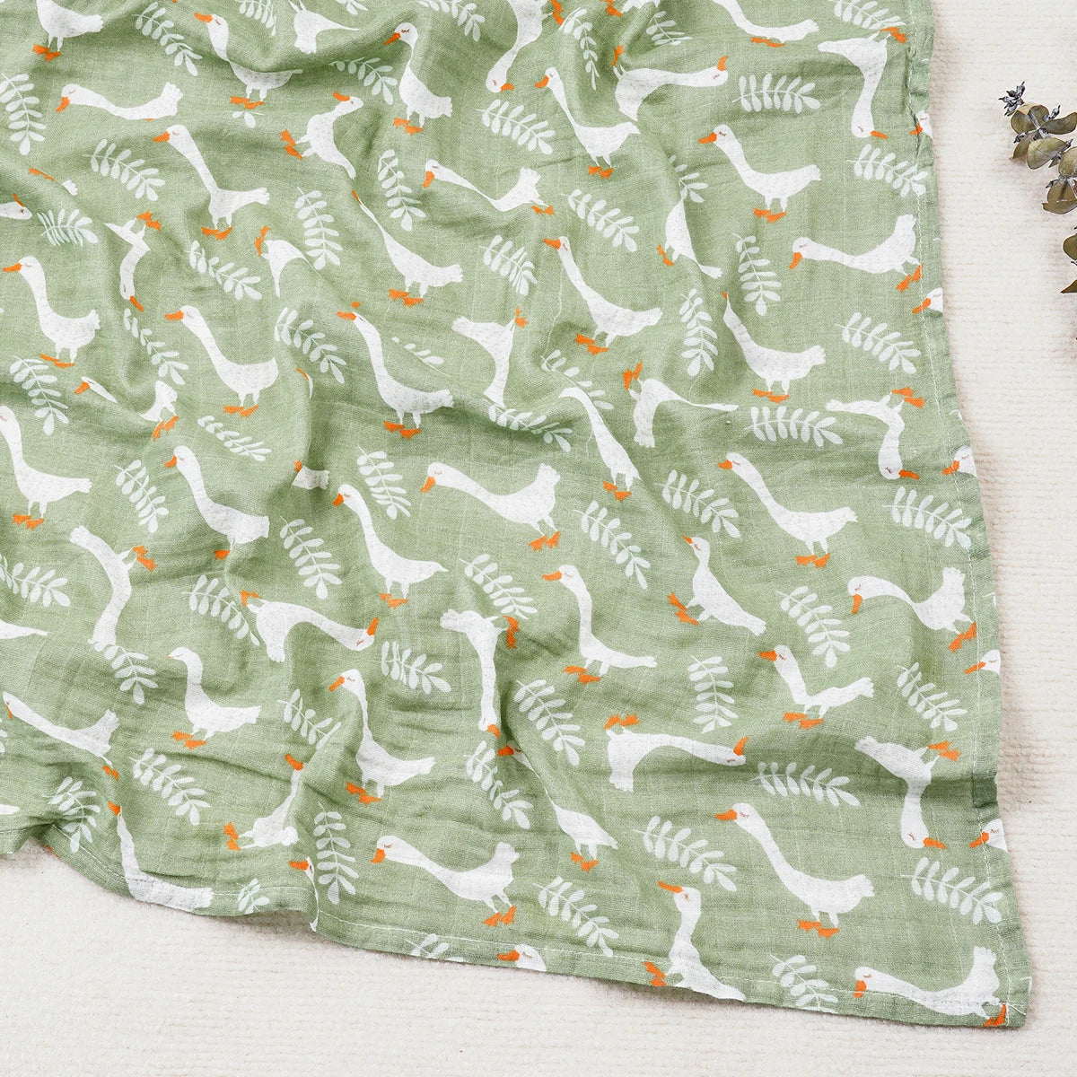 Green fabric with white goose pattern on a light background
