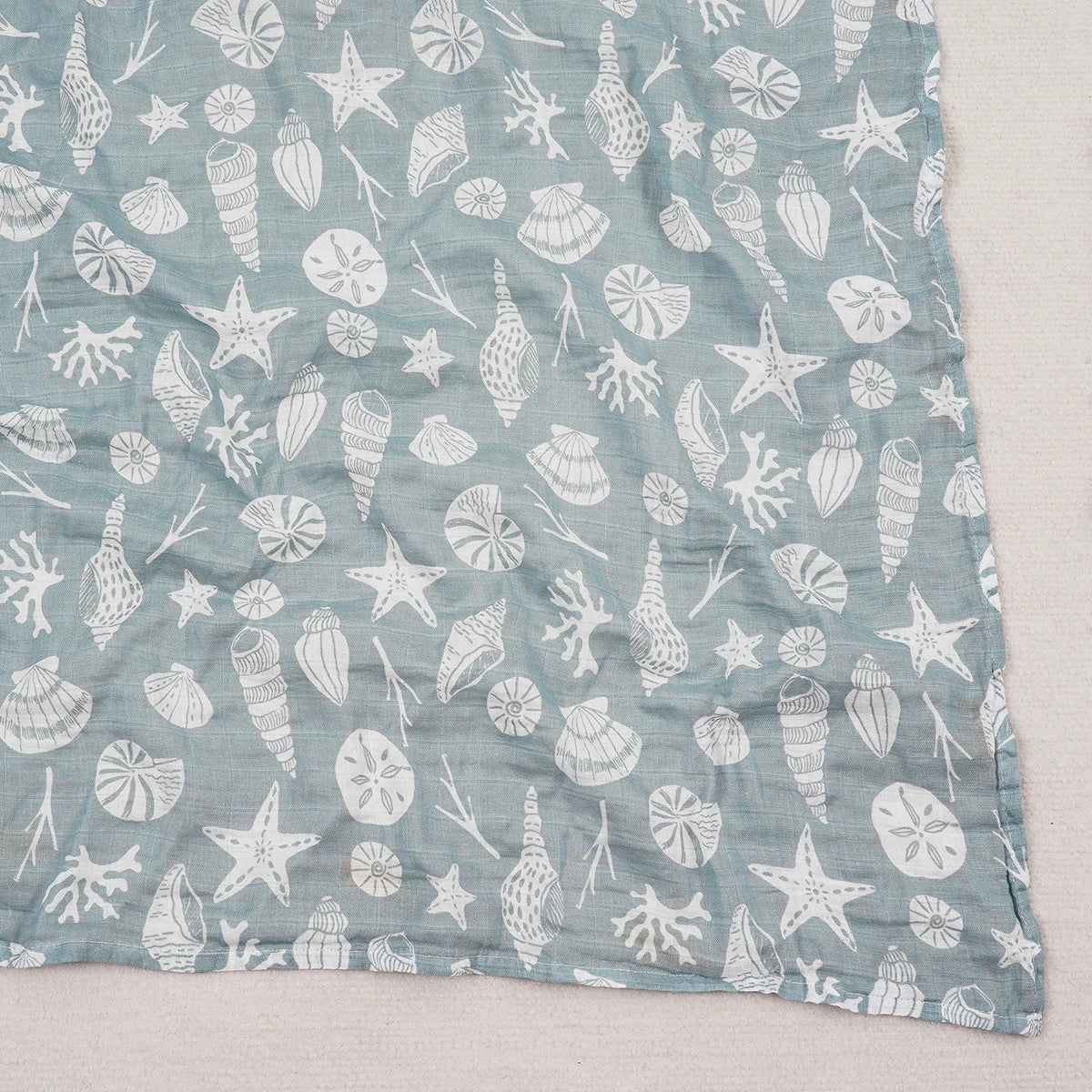 Blue fabric with white sea-themed pattern on a light gray background