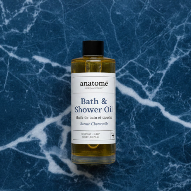 Bottle of anatomé Bath & Shower Oil on a blue marble background