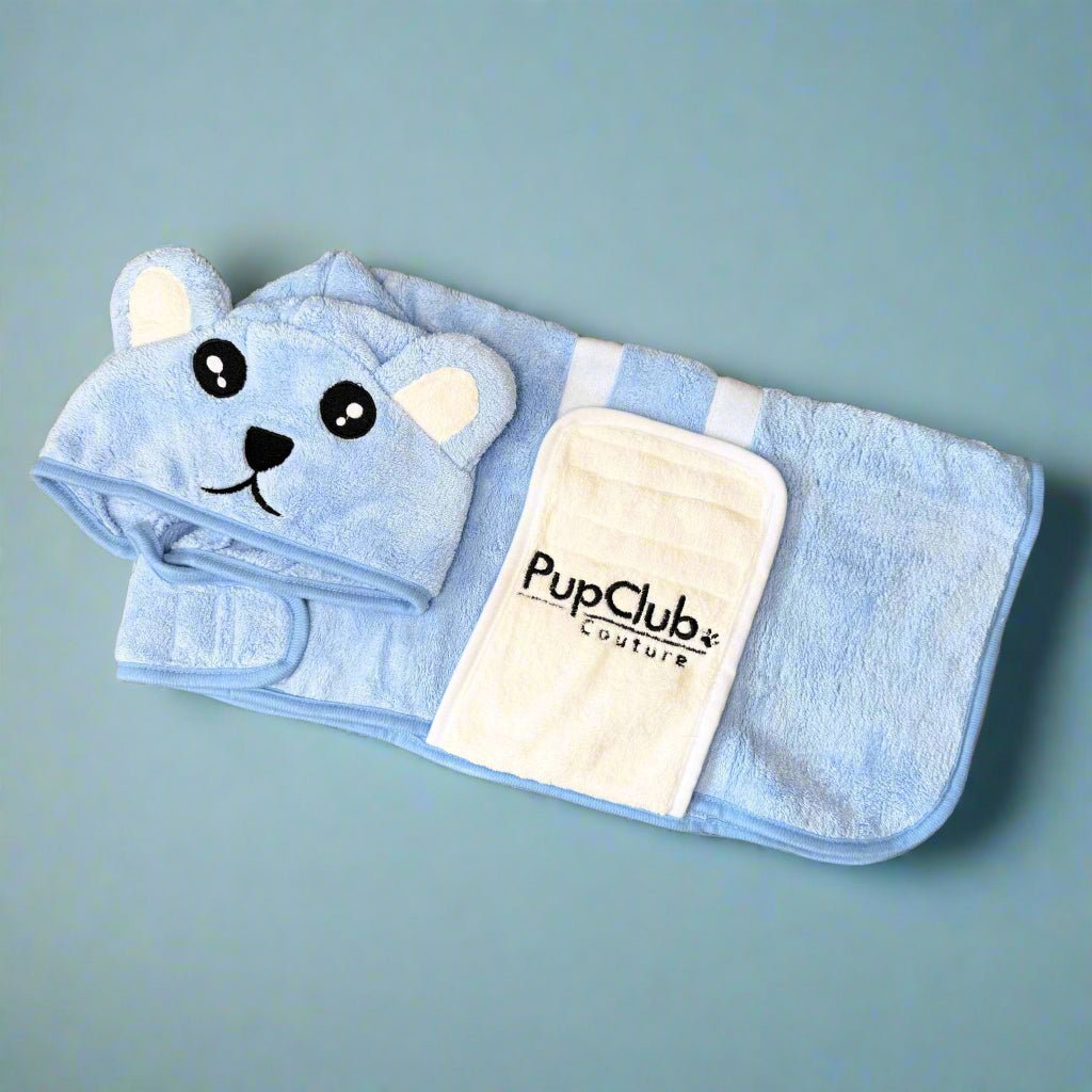 Blue pet hooded towel with bear ears and face on a light blue background, featuring the PupClub Couture logo.