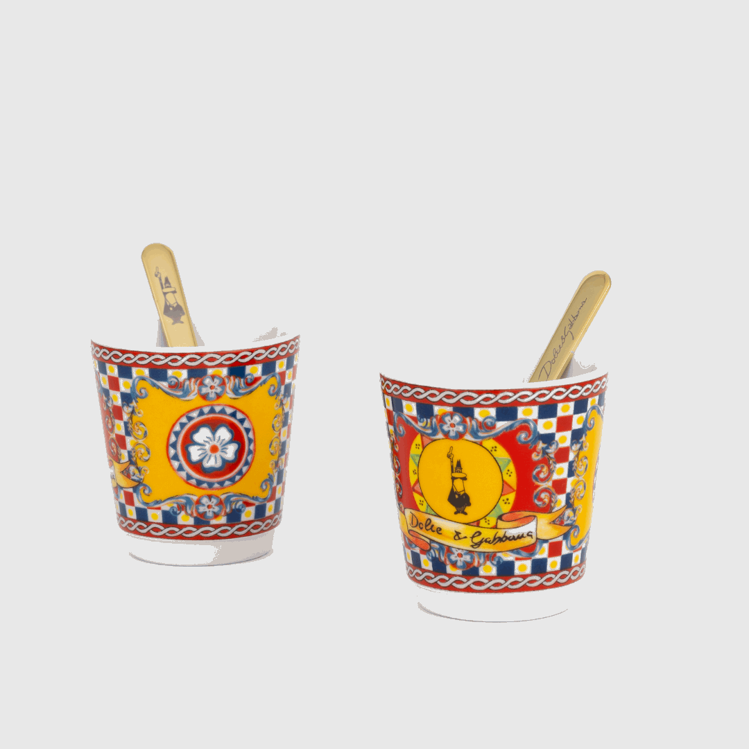 Two colorful ice cream buckets with decorative patterns and wooden spoons on a white background.