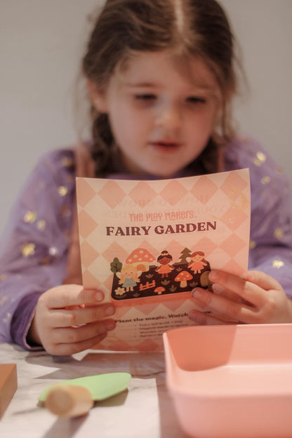 Child holding a fairy garden kit with a pink cover