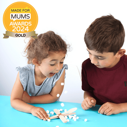 Two children playing with small objects on a blue surface, with a 'Made for Mums Awards 2024 Gold' badge in the corner.