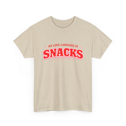A light beige crewneck t-shirt with a red graphic text print reading 'MY LOVE LANGUAGE IS SNACKS' on the chest, displayed against a solid white background.