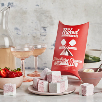 Strawberry cream marshmallows on a plate with a red 'Naked Marshmallow Co' package in the background.