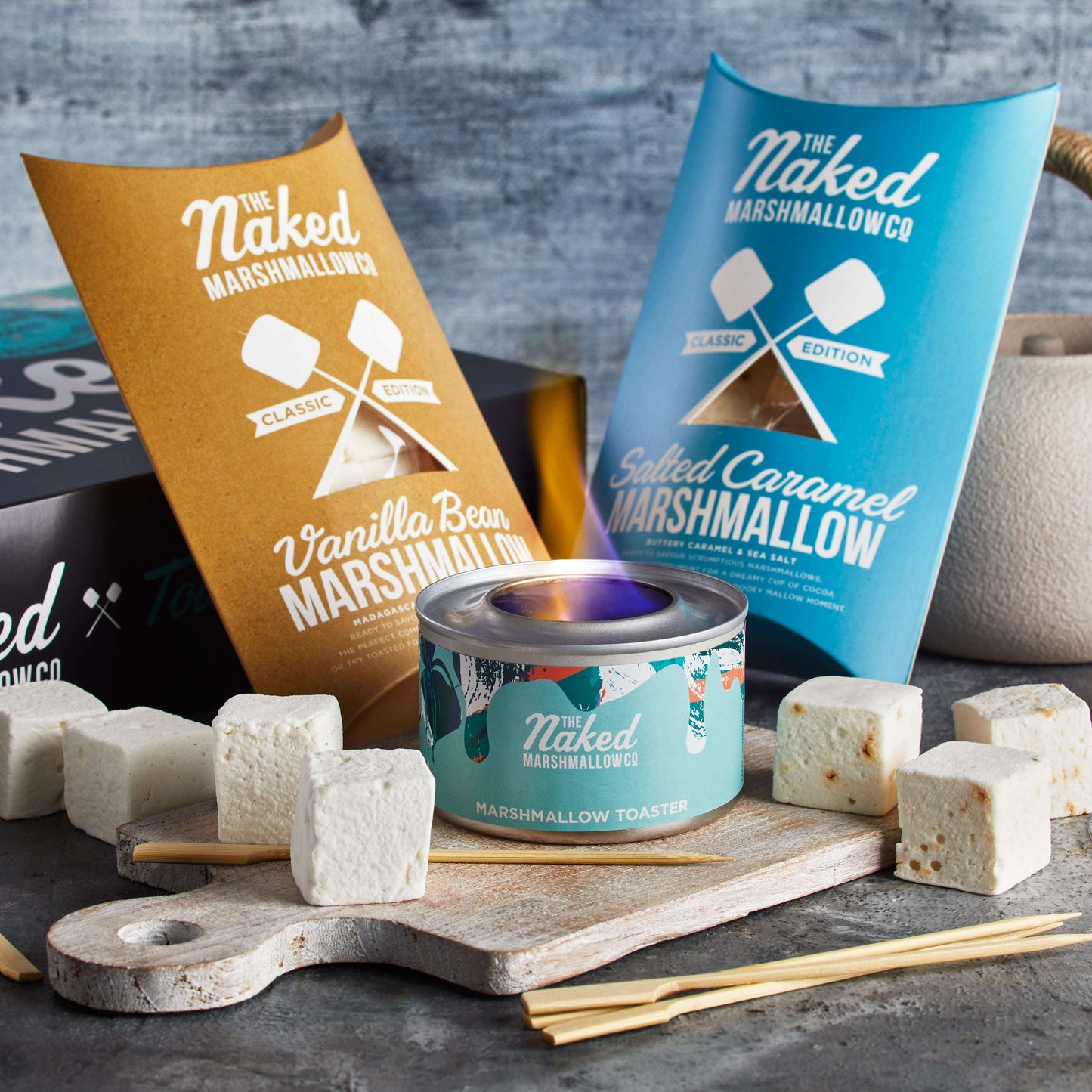 Naked Marshmallows packaging and marshmallows on a wooden board with a gray background