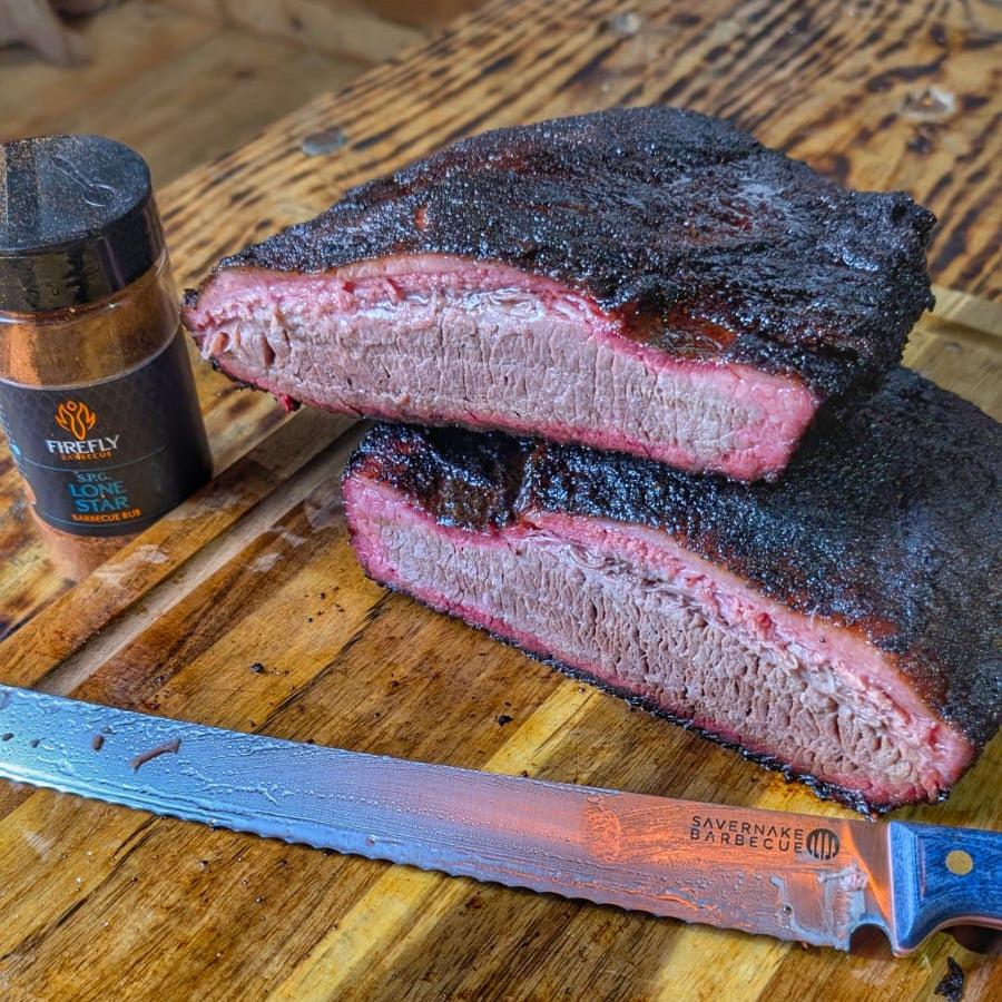 Sliced smoked brisket on a wooden cutting board with a knife and spice jar.