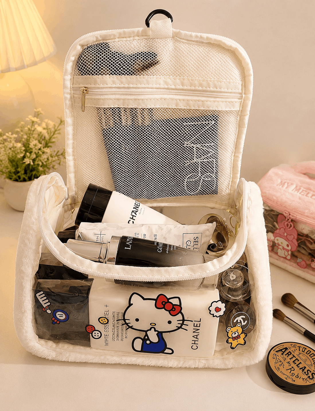 White travel toiletry bag with cosmetic products including a Chanel bottle, on a light surface.