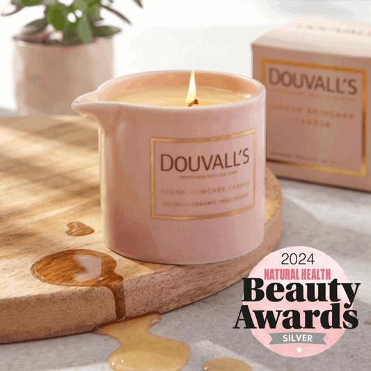 Pink Douvall's candle on a wooden board with a 2024 Natural Health Beauty Awards badge.