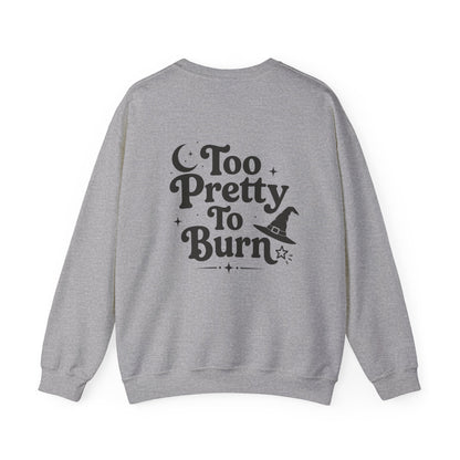 A heather gray crewneck sweatshirt shown from the back, featuring a black graphic print that reads 'Too Pretty To Burn' with a witch hat and stars.