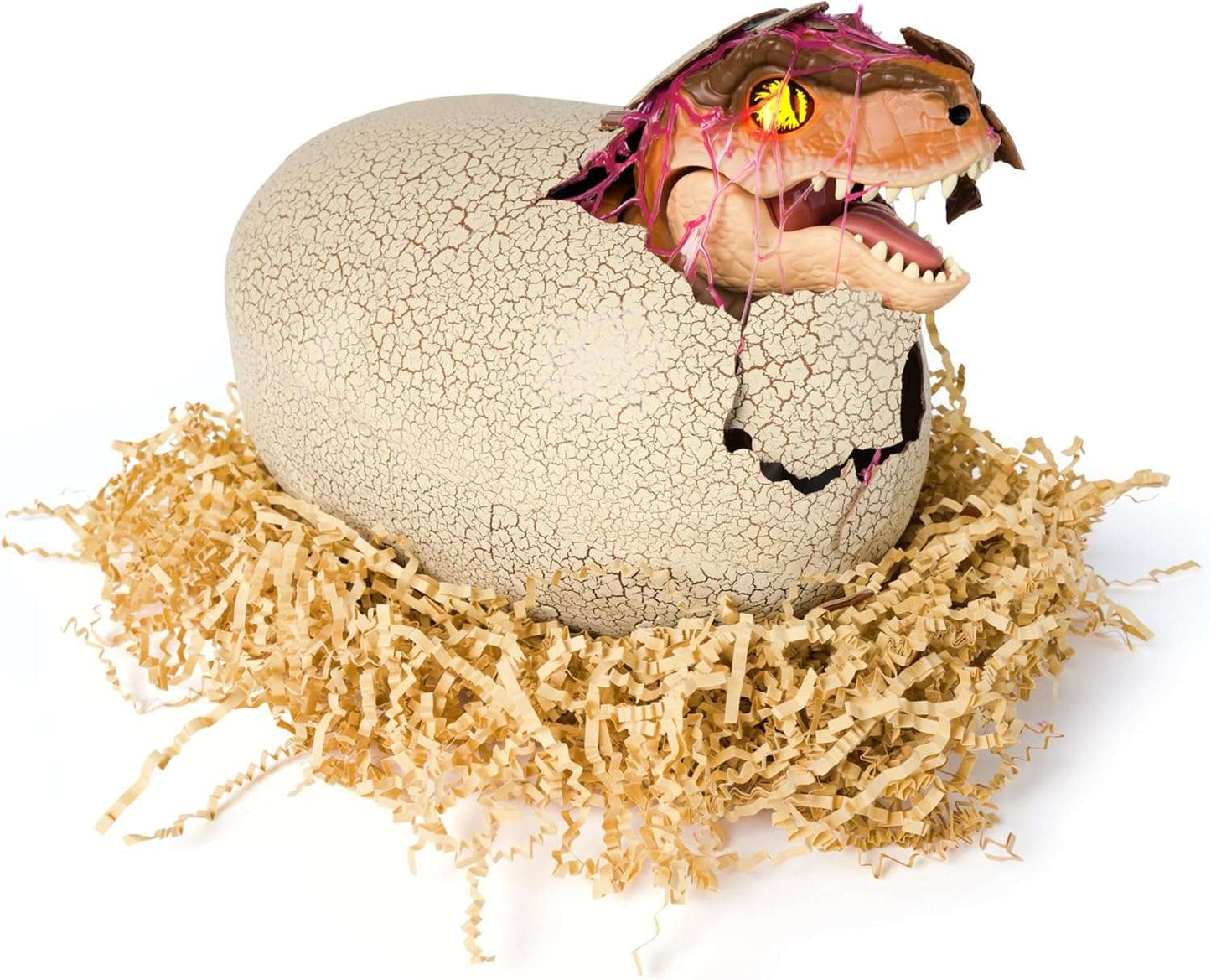 Toy dinosaur emerging from a cracked egg on a bed of straw with a white background