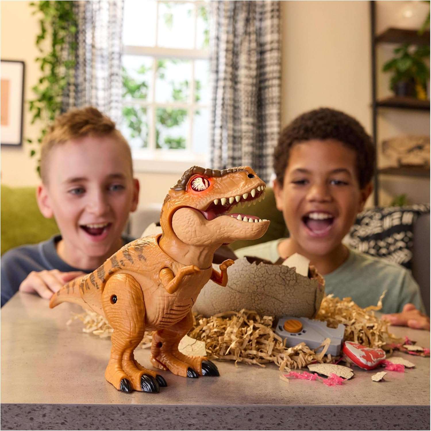 Two children playing with a toy dinosaur on a table.