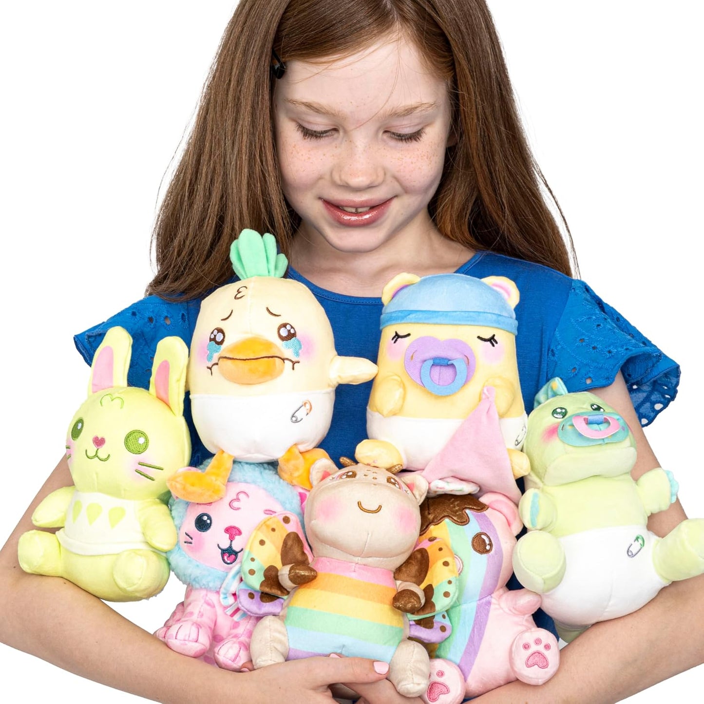 Girl holding a collection of colorful plush toys against a white background