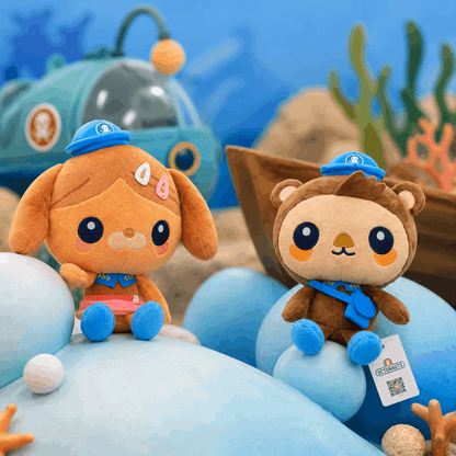 Two plush toys resembling a dog and a bear with blue hats on an underwater-themed background.
