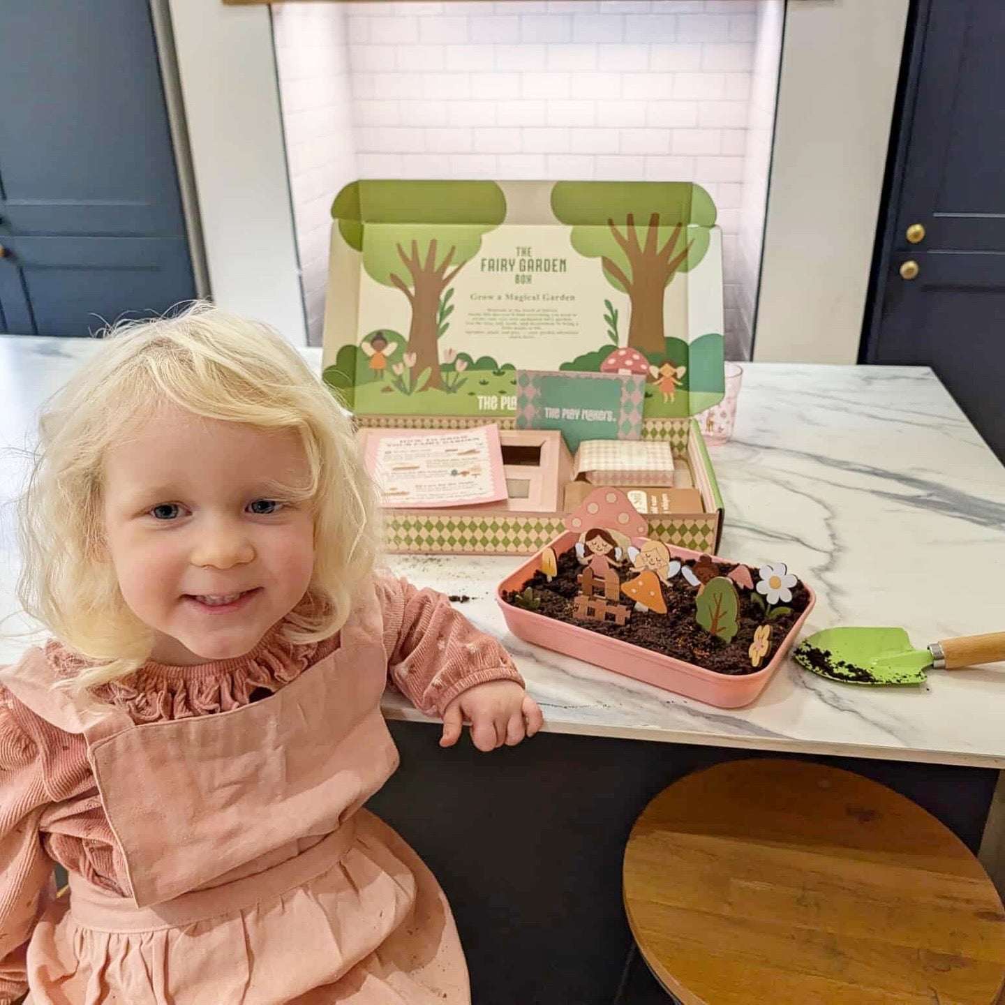 Child with a fairy garden kit on a table