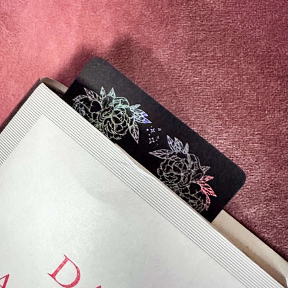 Floral bookmark on a book with a pink textured background