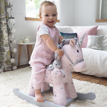 Child playing with a pink rocking horse toy in a cozy living room.