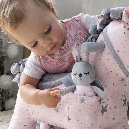 Child playing with a plush toy on a star-patterned chair