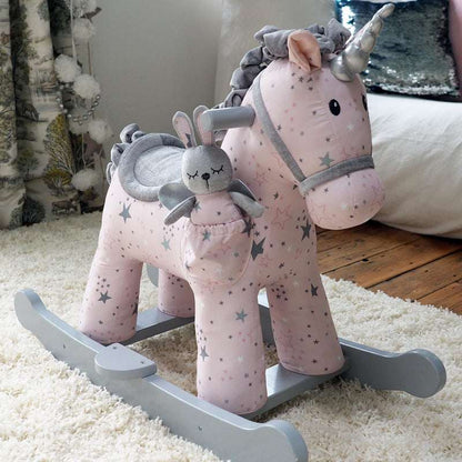 Pink rocking horse with a gray bunny toy on a carpeted floor.
