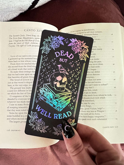 Black bookmark with colorful text and design held over an open book