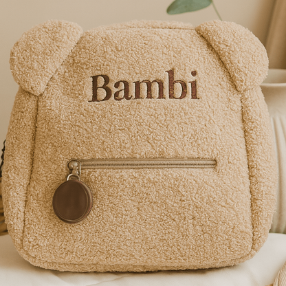 Beige teddy bear-shaped bag with 'Bambi' text on a light surface.