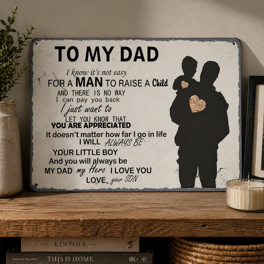 Decorative sign for a father with a silhouette of a man holding a child, placed on a shelf.