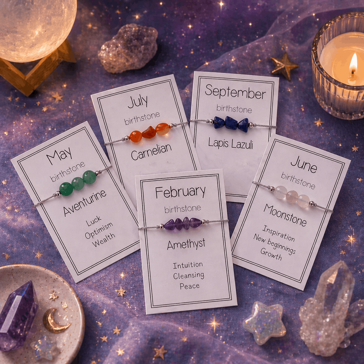 Set of birthstone bracelets with corresponding cards on a mystical background with crystals and candles.