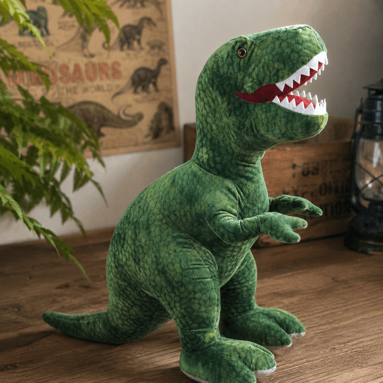 Green dinosaur plush toy on a wooden floor with a poster in the background
