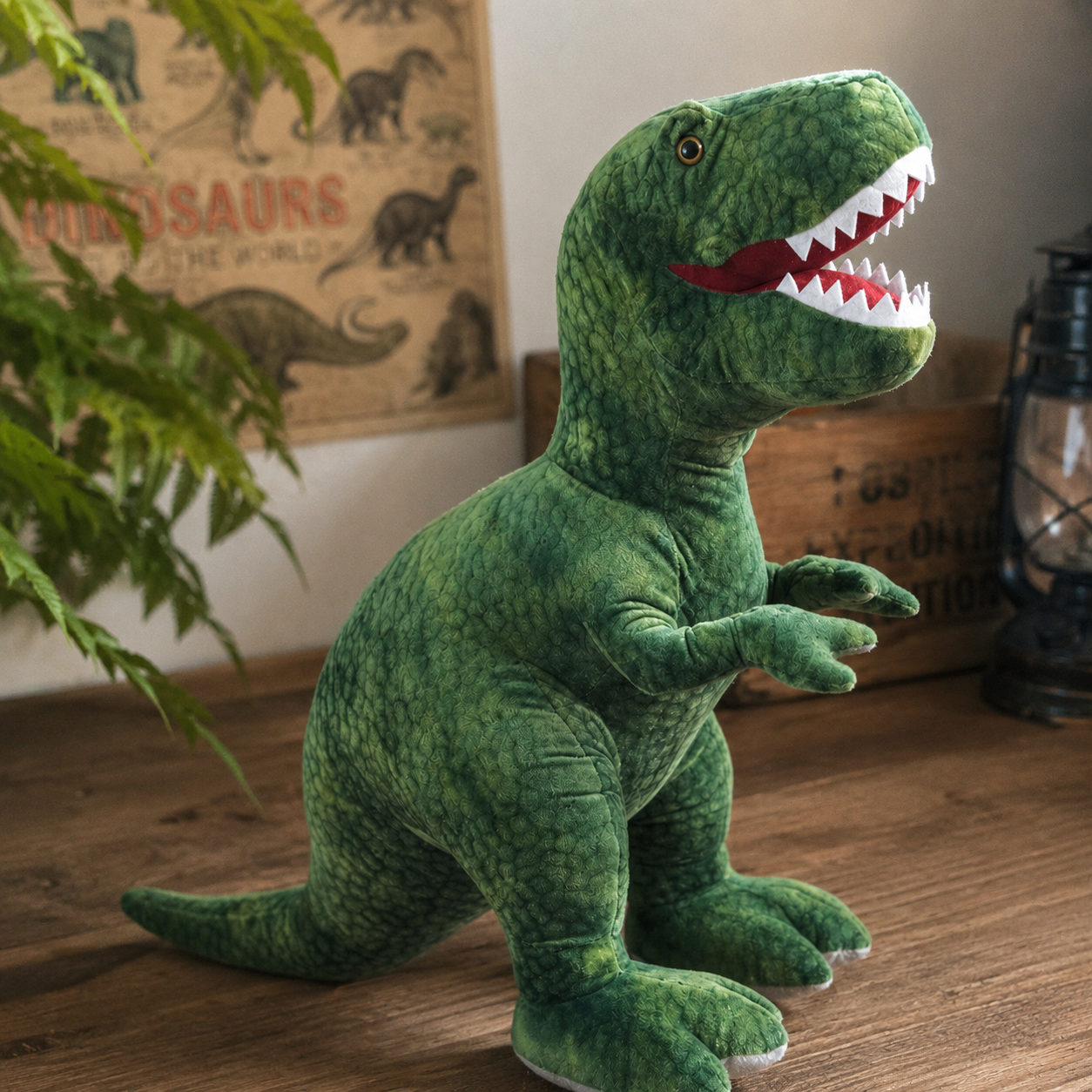 Green dinosaur plush toy on a wooden floor with a poster in the background