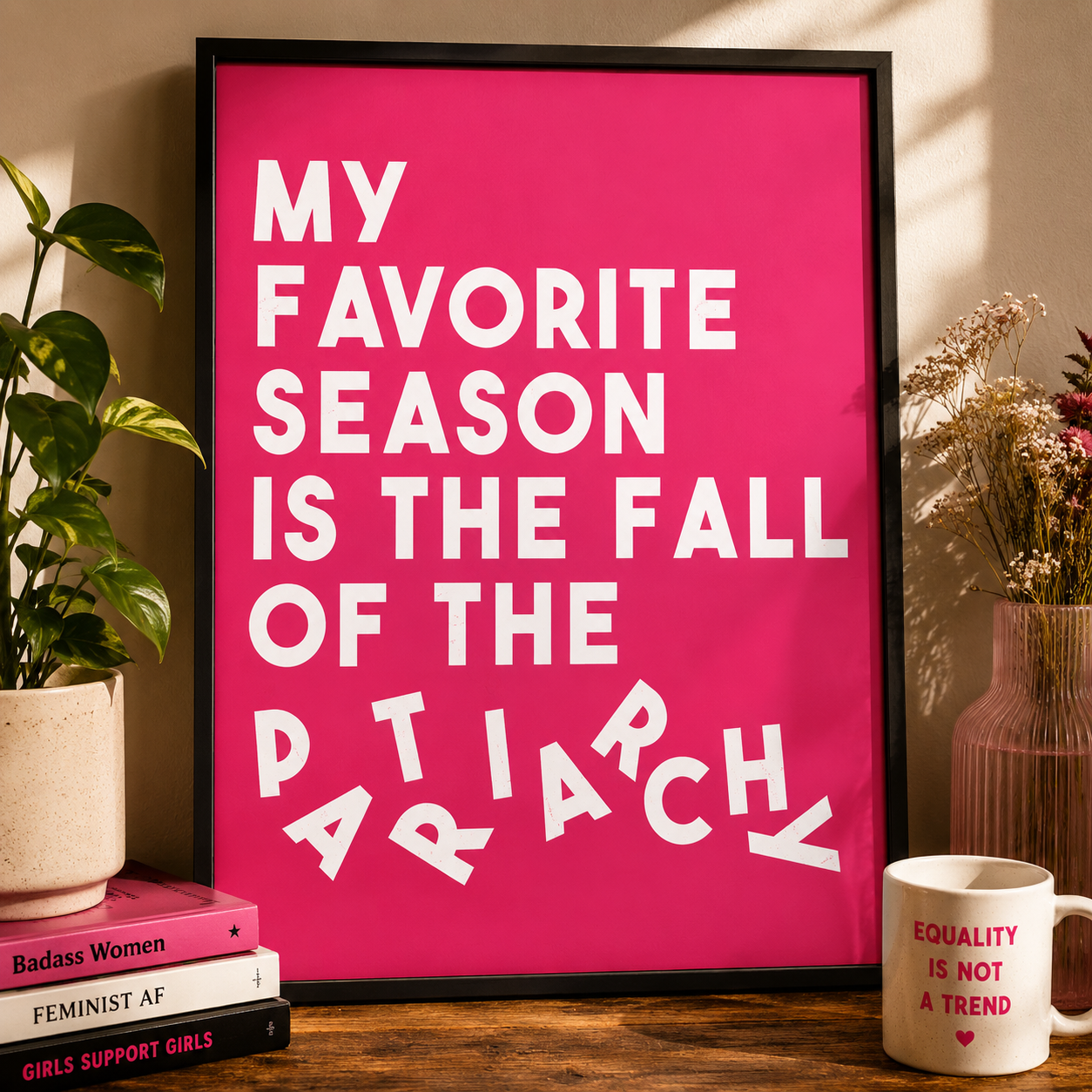 Framed poster with feminist text on a table with decor items