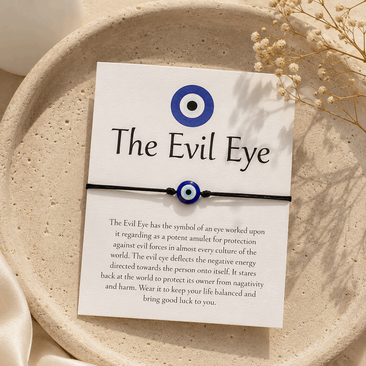 Evil Eye bracelet on a card with text on a beige plate