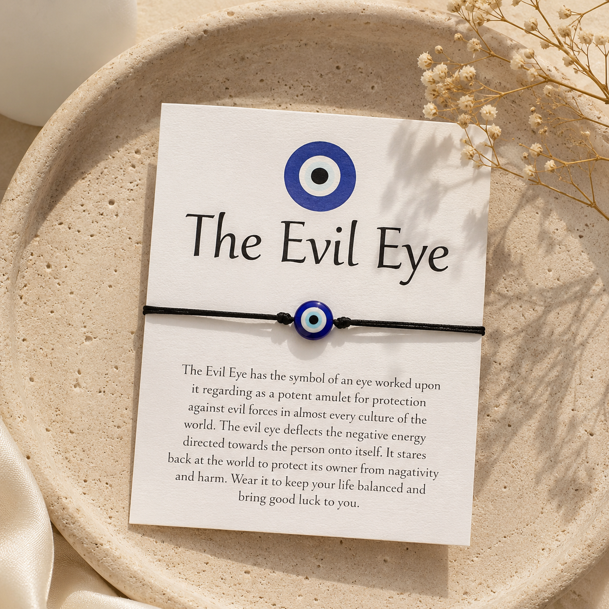 Evil Eye bracelet on a card with text on a beige plate