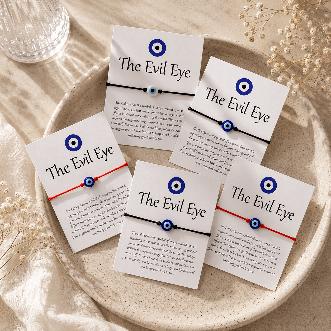 Multiple 'The Evil Eye' bracelets on cards with text on a beige plate.