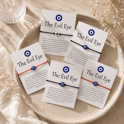 Multiple 'The Evil Eye' bracelets on cards with text on a beige plate.