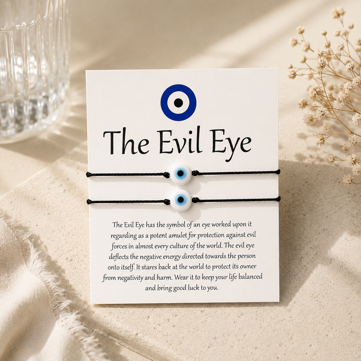 Evil eye bracelet set with card explaining the symbol on a beige surface.
