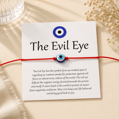 Evil eye bracelet with card explaining its symbolism on a beige background