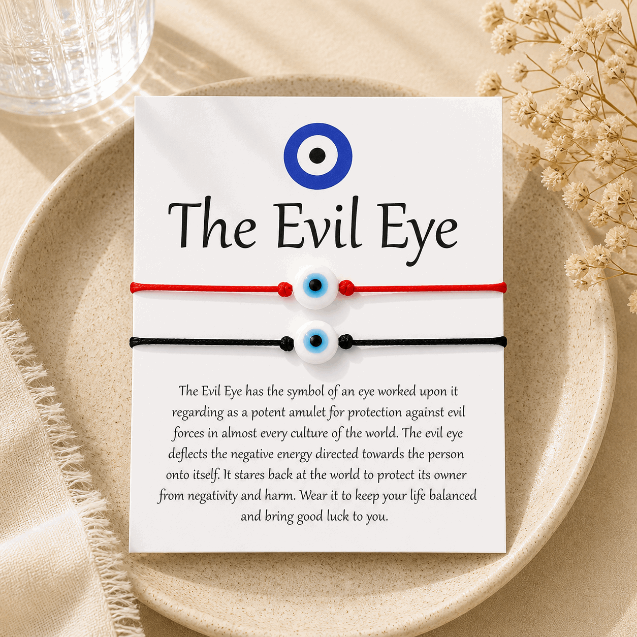 Bracelets with 'The Evil Eye' symbol on a card with text about the symbol, placed on a textured surface.