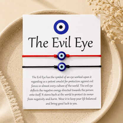 Evil eye bracelet on a card with text about its meaning, displayed on a beige plate.